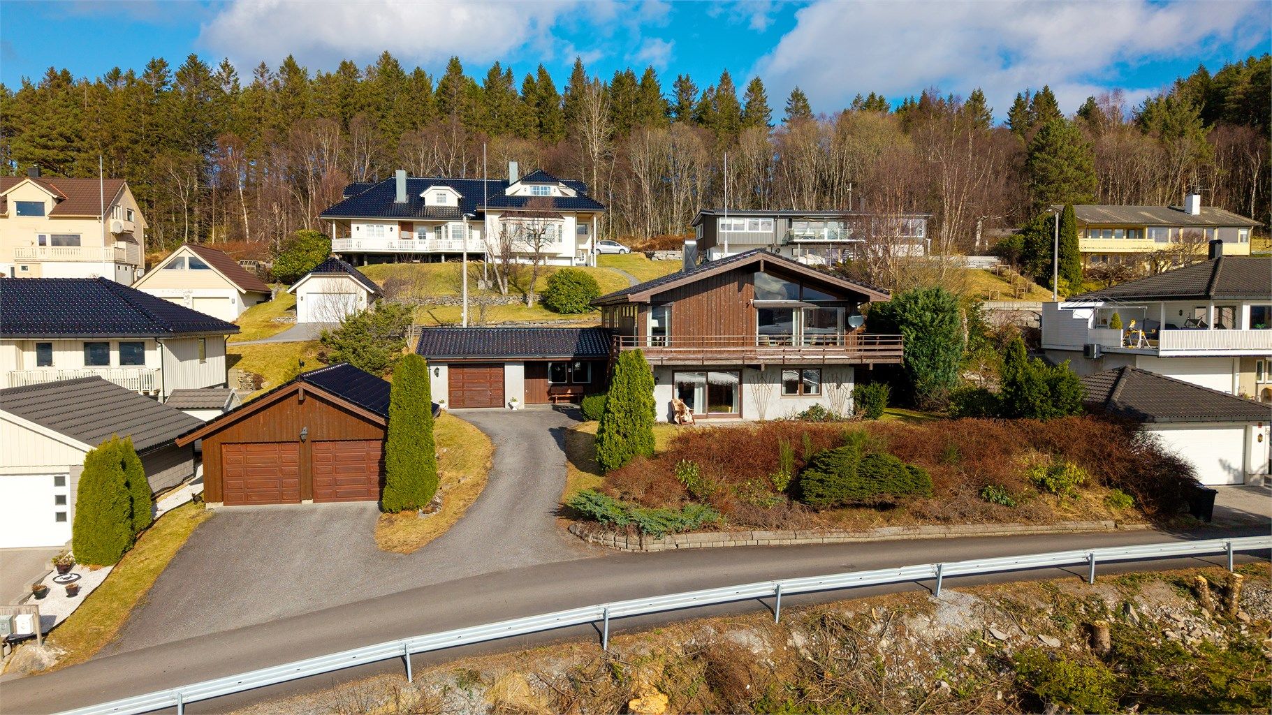 Eiendommen har en stor, opparbeidet tomt og totalt tre garasjeplasser, inkludert en dobbelgarasje med lagringshems