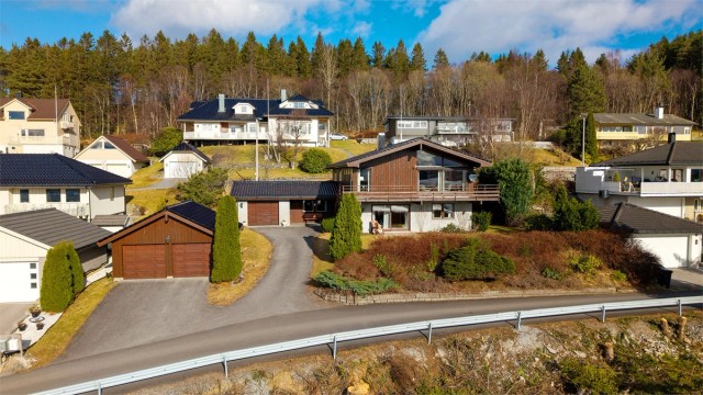 Eiendommen har en stor, opparbeidet tomt og totalt tre garasjeplasser, inkludert en dobbelgarasje med lagringshems
