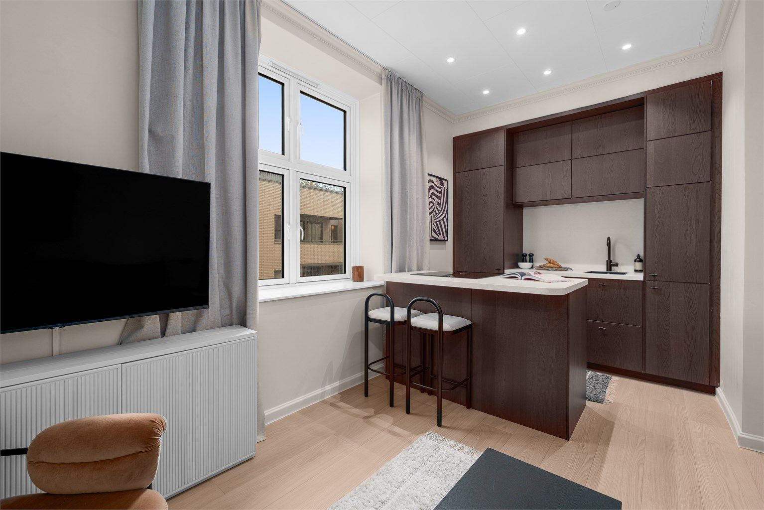 Den åpne løsningen mot kjøkkenet er perfekt for en sosial sone, og er godt utnyttet med både skap- og benkplass. Kjøkkenet ble satt inn i 2023