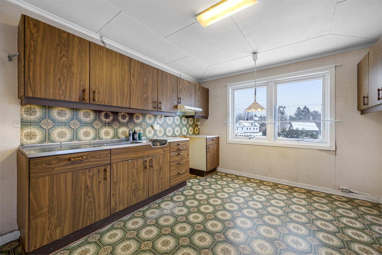 Kjøkkenet i første etasje har en eldre innredning med glatte fronter.