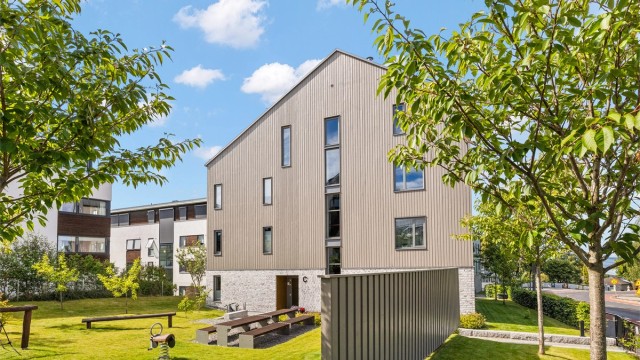 Fellesarealene er pent opparbeidet med plenarealer, beplantning og sittegrupper.