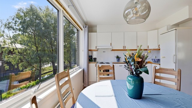 Spiseplassen på kjøkkenet har store vinduer mot øst som gir flott lysinnfall og koselig utsikt mot Kvernstubekken og sentrumsbebyggelsen