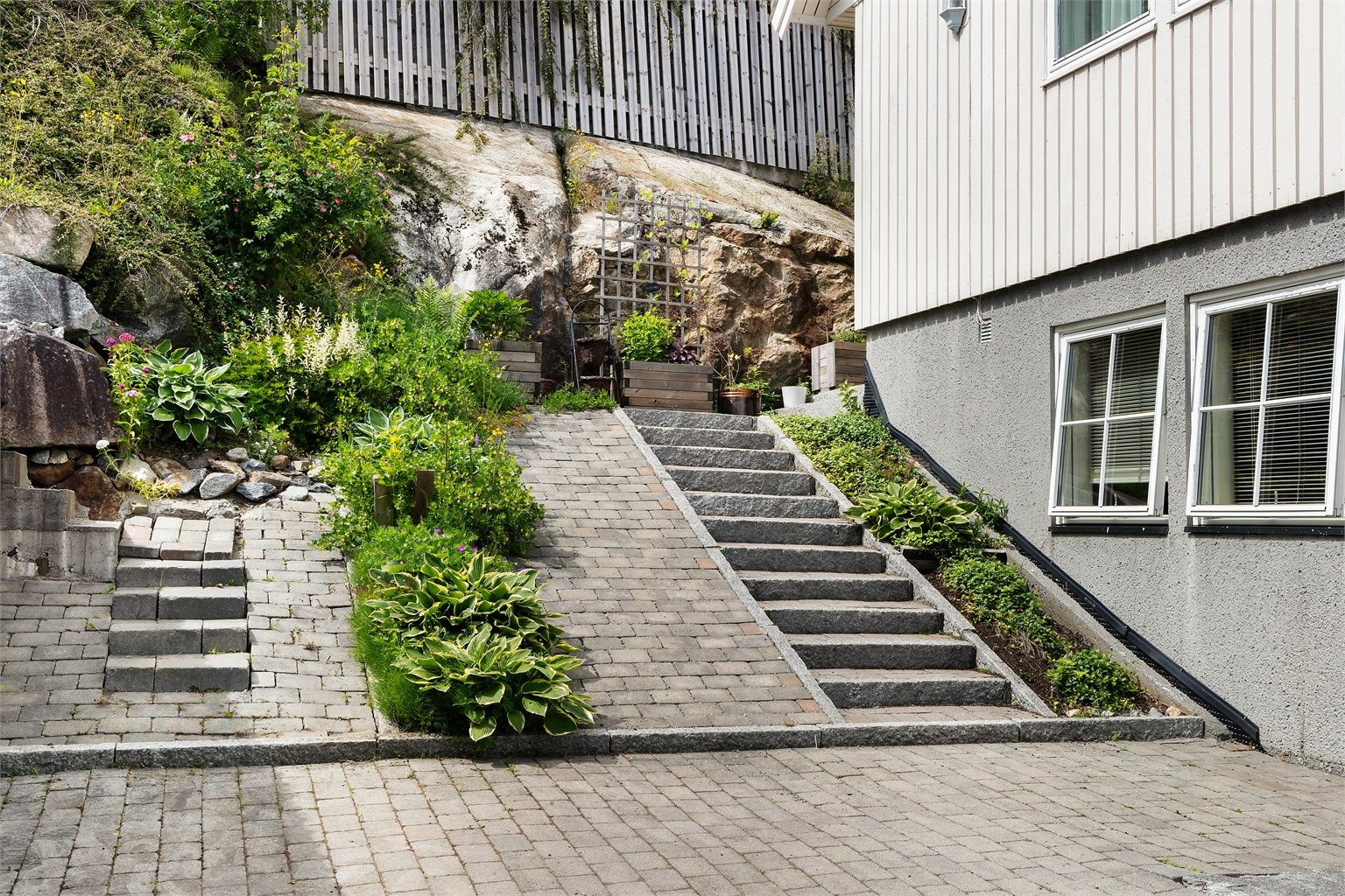 Tomten er opparbeidet med forstøtningsmurer i betong og naturstein.