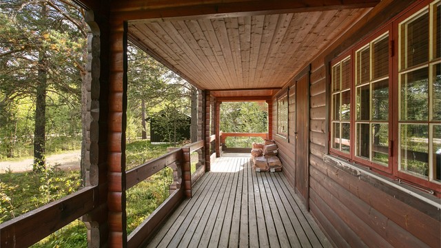 Overbygd terrasse som strekker seg langs fasaden og skjermer for vær og vind.