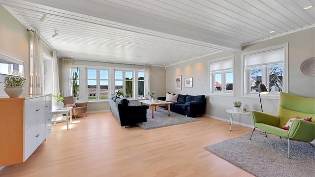 Stuen er romslig med plass til flere soner, og har parkett på gulv og malte panel i tak.