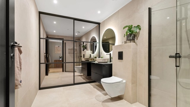 Innholdsrikt og flislagt bad med gulvvarme. Bak skyvedørsgarderobe skjuler det seg både opplegg til vaskemaskin/tørketrommel, ekstra oppbevaring og klesoppheng.