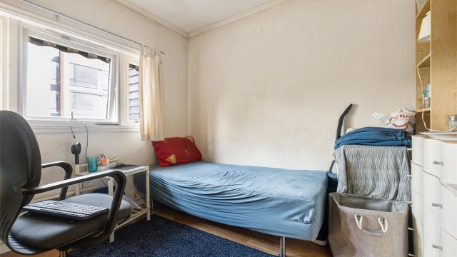 Soverom med plass til seng og oppbevaringsmøbler.