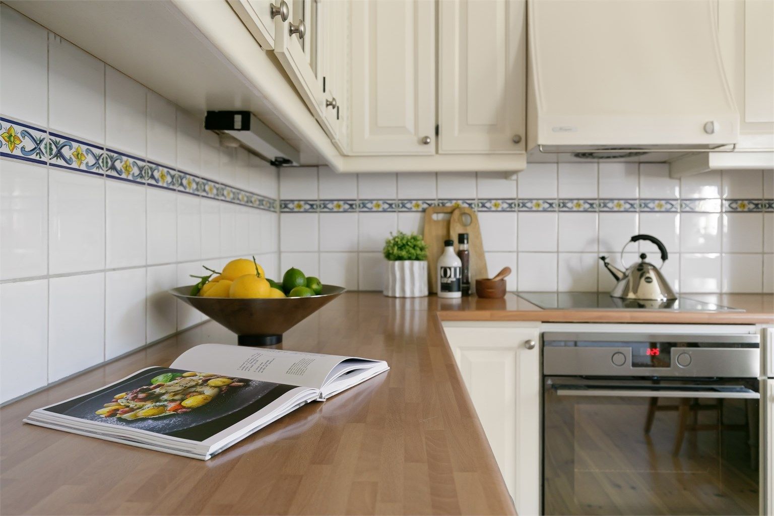 Kjøkkenet har profilerte fronter på skap og skuffer, og laminat benkeplate