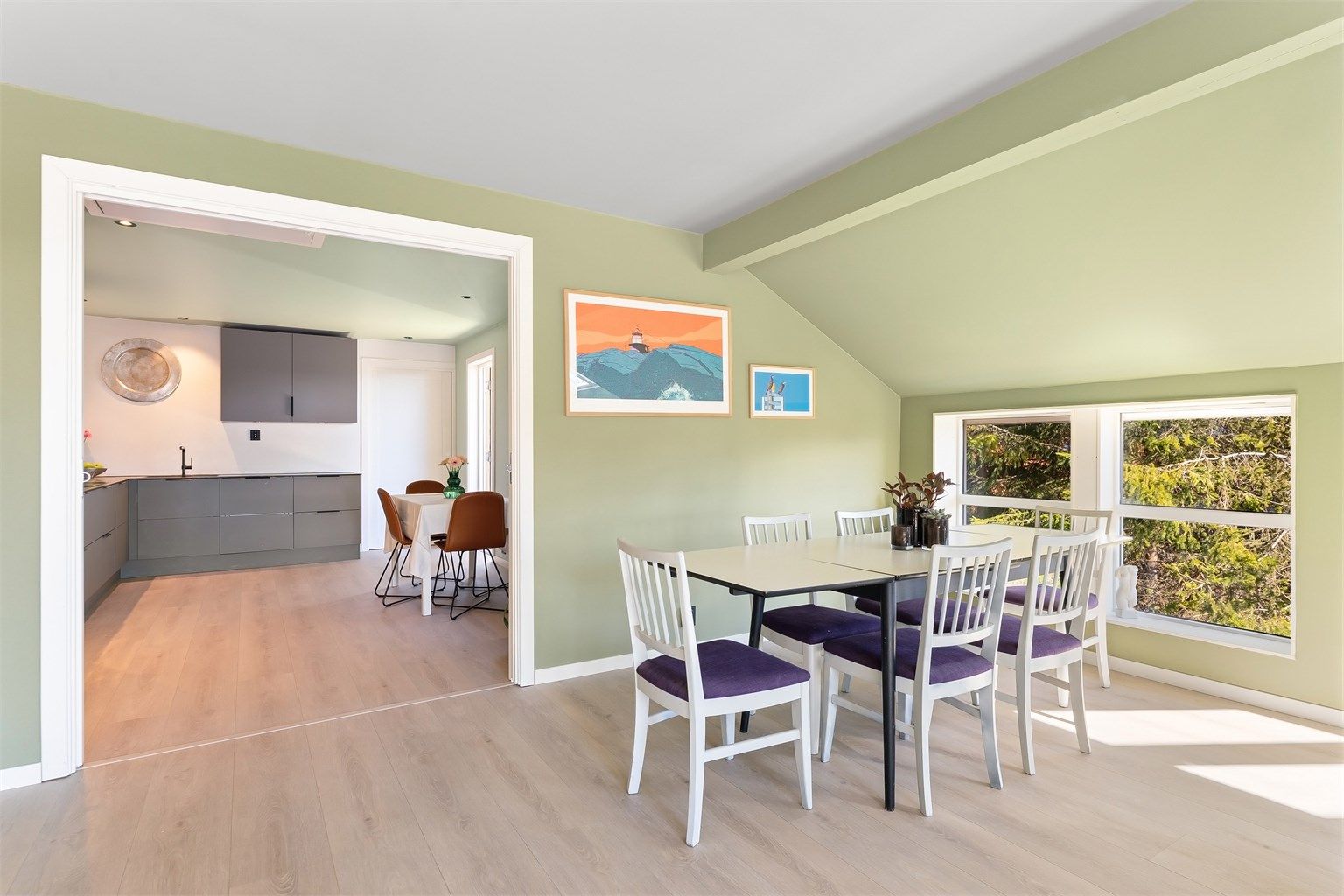 Fra spisestuen er det en åpen løsning mot kjøkkenet, noe som skaper en sosial og luftig atmosfære.