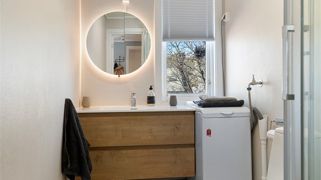 Flislagt bad med varme i gulvet og opplegg for vaskemaskin.