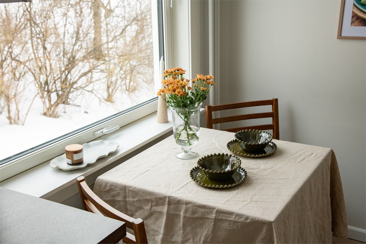 kjøkkenbord plassert ved vinduet, hvor naturlig lys strømmer inn.