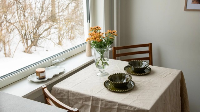 kjøkkenbord plassert ved vinduet, hvor naturlig lys strømmer inn.