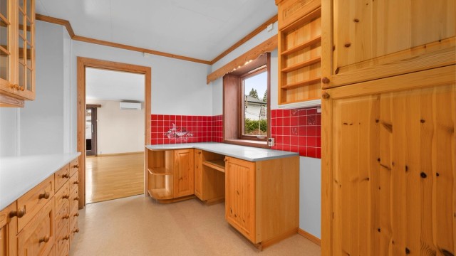 En praktisk kjøkkenløsning med integrert ventilator og helbeslått oppvaskkum i rustfritt stål.