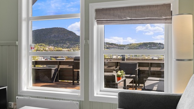 Vinduene i stuen rammer inn utsikten mot terrassen og landskapet utenfor.