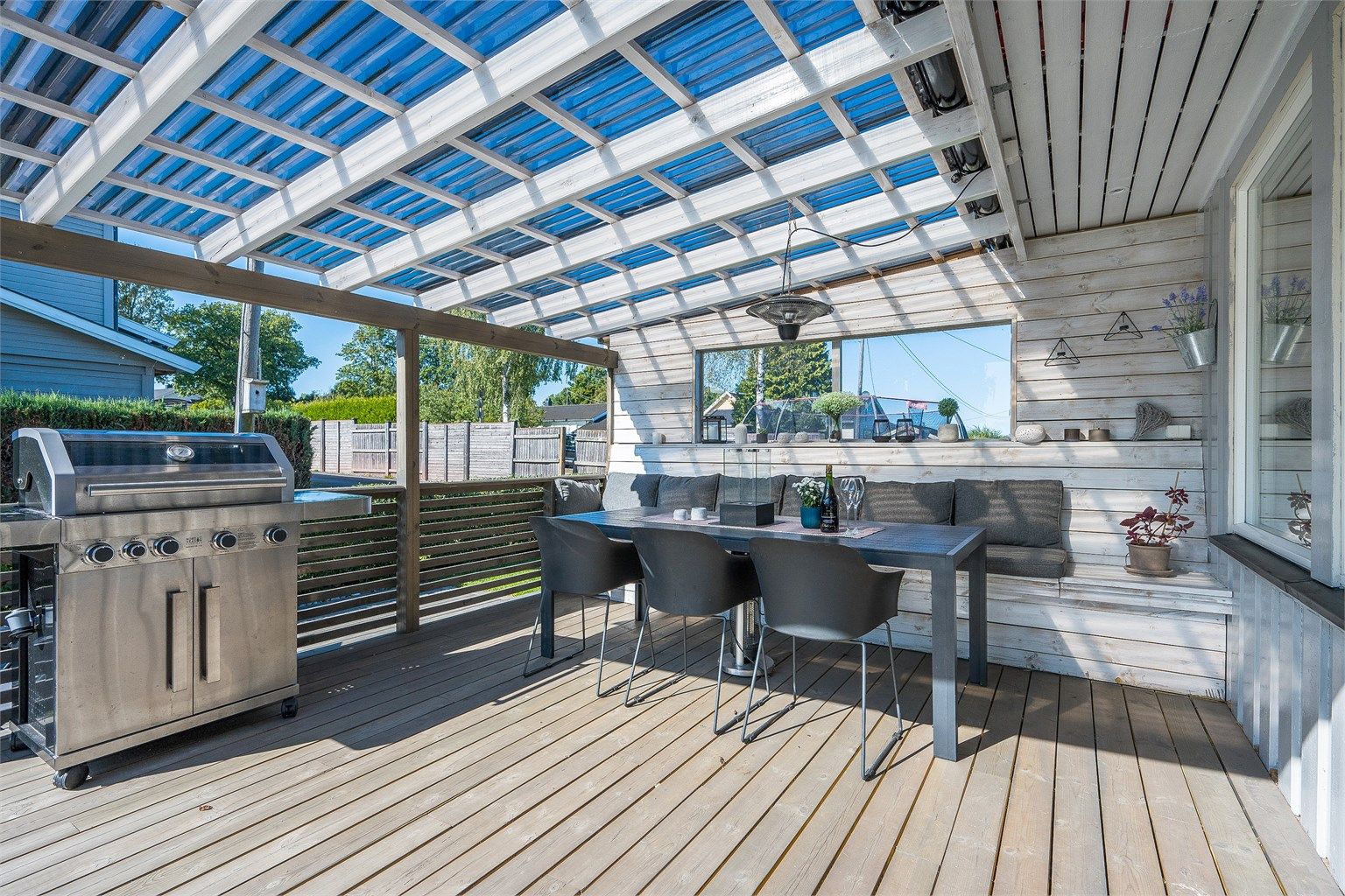 Overbygd terrasse mot vest med plassbygde hyller og  benker. Fotograf: Kristian Bollæren / Fotofinish AS.