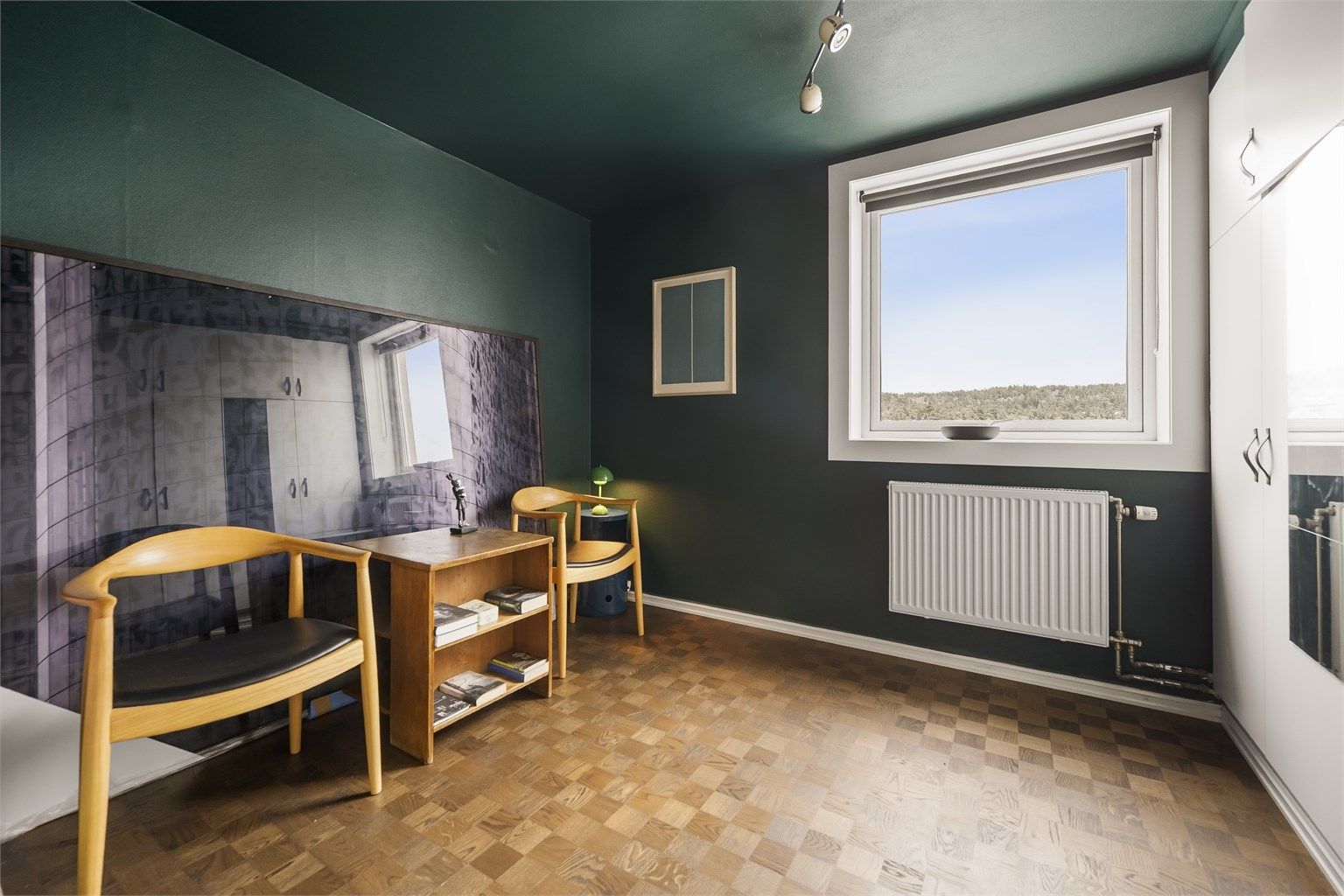 Vindu mot øst og utsyn mot tretoppene i Østmarka.