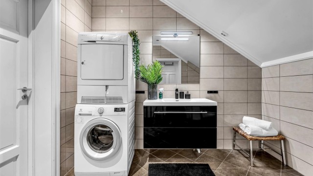Badet i 3. etasje er flislagt og har opplegg for vaskemaskin og tørketrommel.
