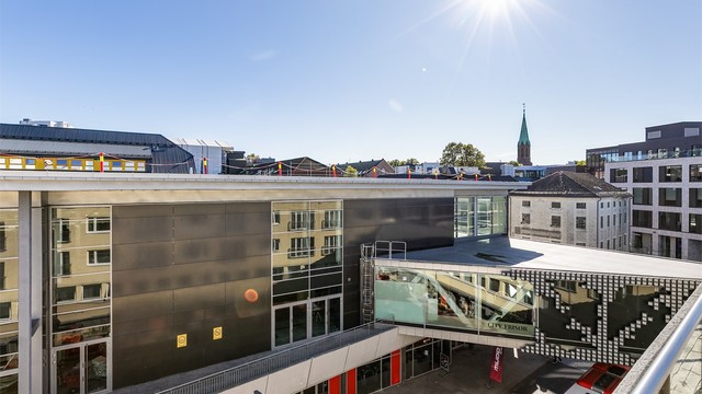 Rett over gaten ligger byens store kjøpesenter som nylig er pusset opp og inneholder et større antall forretninger.