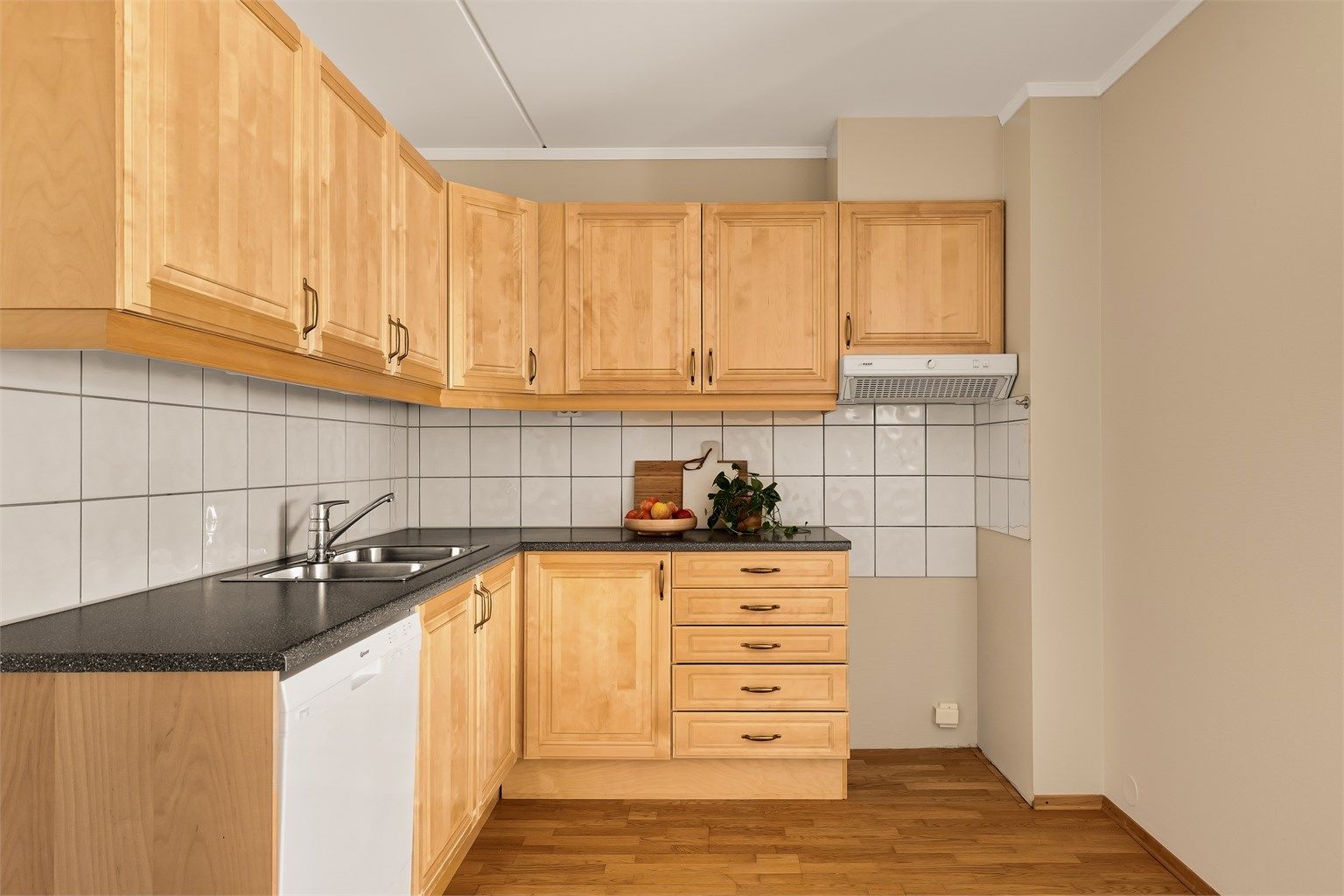 Kjøkken med innredning med profilerte fronter. Benkeplate med laminert overflate og nedfelt kjøkkenvask