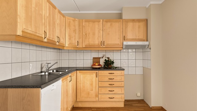 Kjøkken med innredning med profilerte fronter. Benkeplate med laminert overflate og nedfelt kjøkkenvask