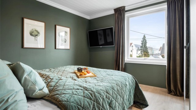 Ett av tre soverom i andre etasje, alle med laminatgulv og panelplater i himling med downlights.