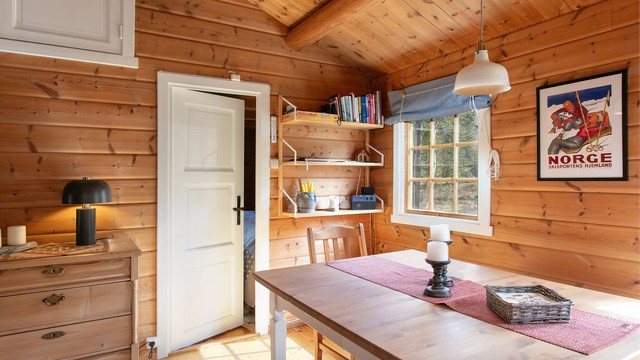 Hyggelig spiseplass ved vinduet med utsikt mot naturtomten.
