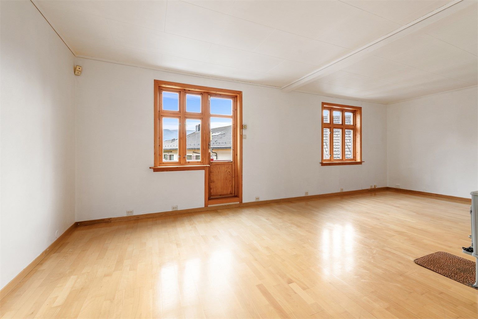 Åpen stue med vindusflater og utgang direkte til sydvendt veranda