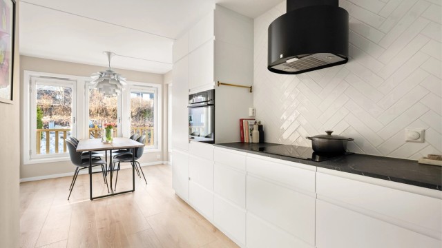 Vegg over benk er flislagt i et delikat fiskebeinsmønster.