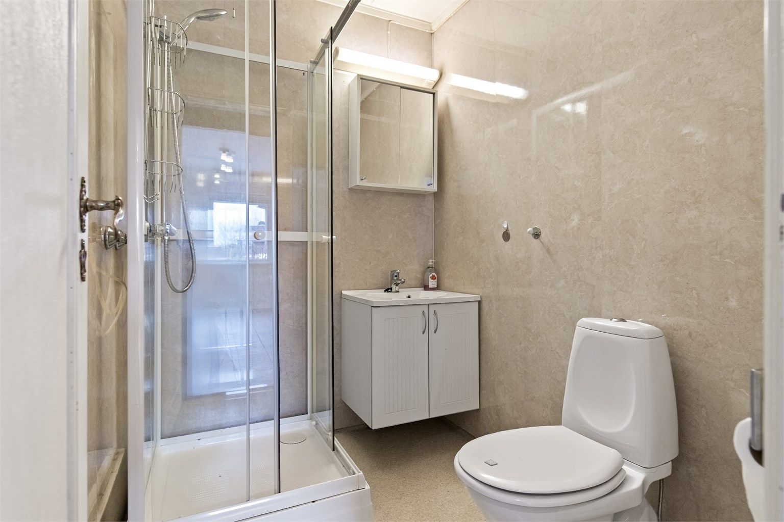 Boligens bad har belegg på gulv, og veggene har våtromsplater.