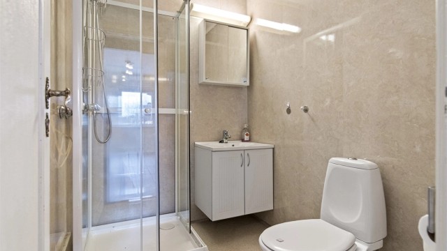 Boligens bad har belegg på gulv, og veggene har våtromsplater.