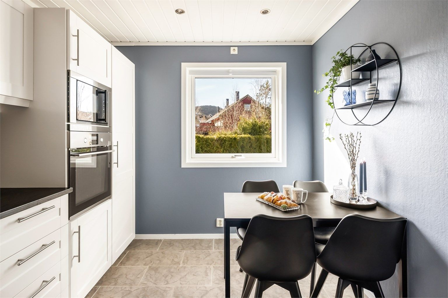 Kjøkkenet har en hyggelig spiseplass ved vinduet.