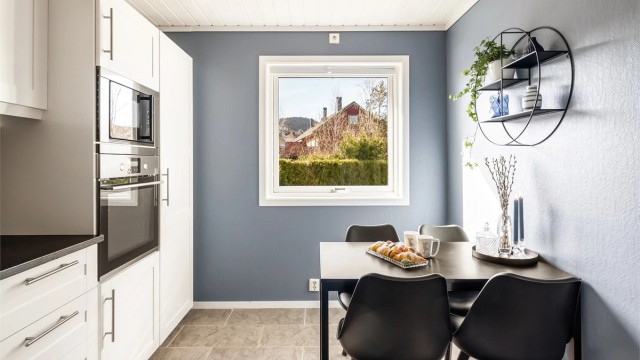 Kjøkkenet har en hyggelig spiseplass ved vinduet.