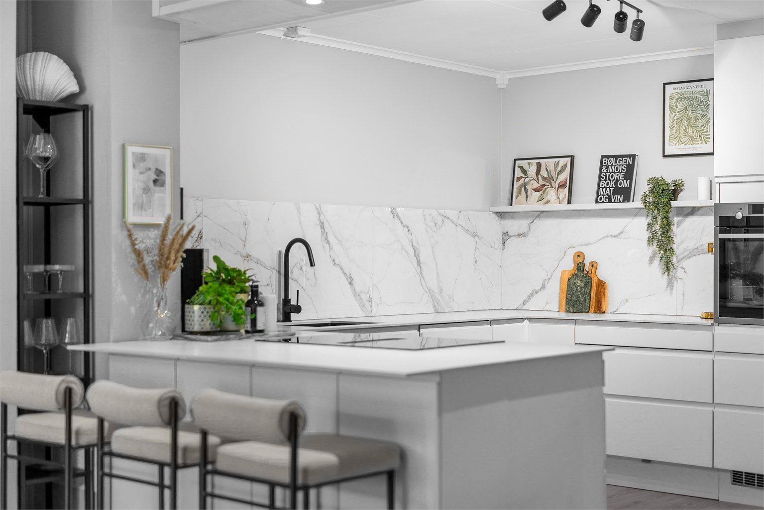 Kjøkkenet har glatt innredning med innfelte håndtak og keramisk benkeplate 