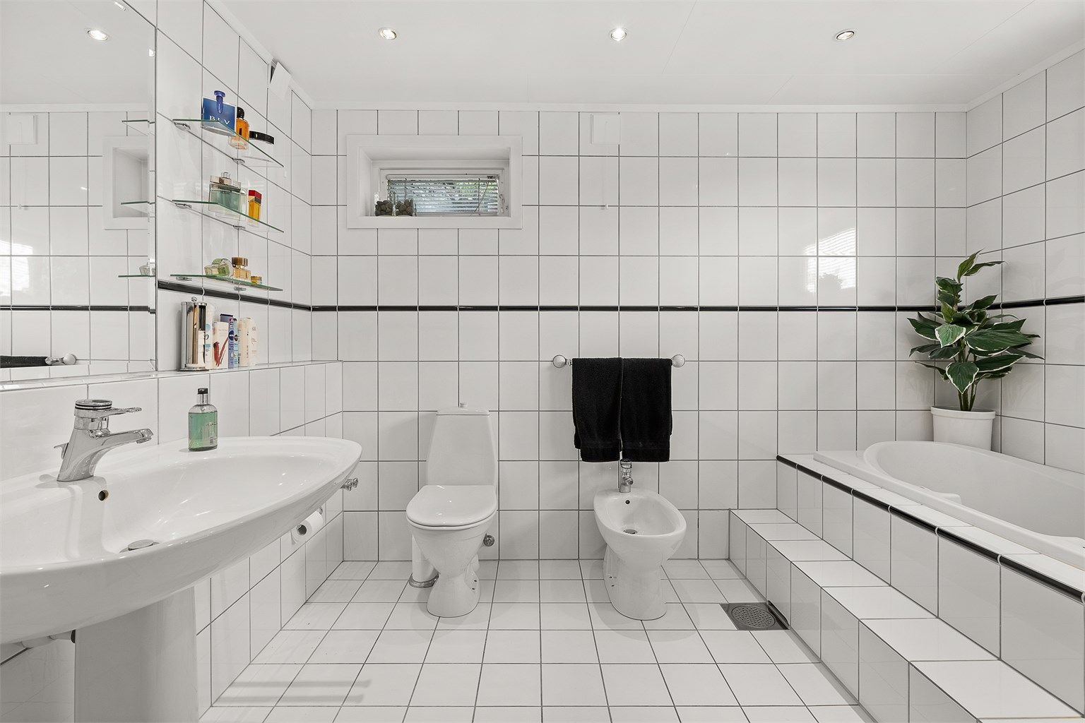 Bad 2 av 4: Et romslig og flislagt bad med gulvvarme og downlights i himling