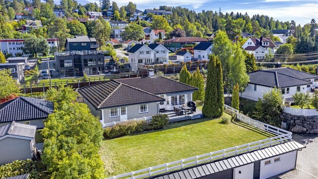 Tomten er pent opparbeidet med blant annet stor hage, diverse beplantninger og solrik platting
