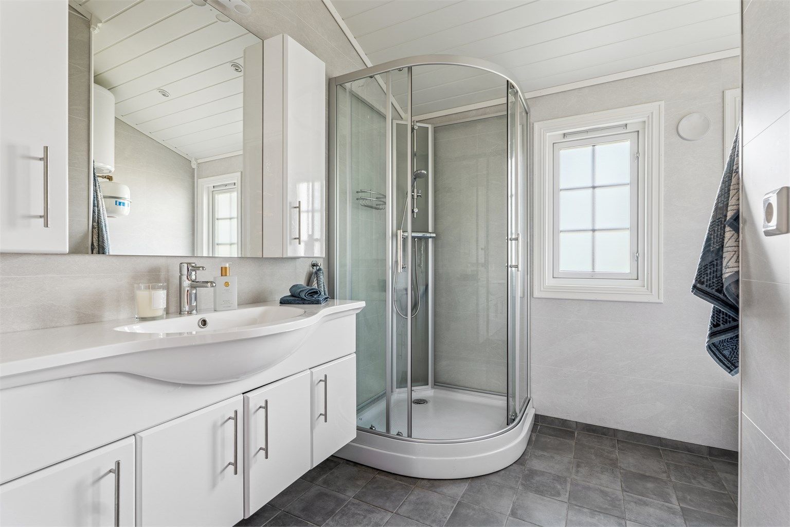 Badet ble oppgradert i 2017 og har flislagt gulv med gulvvarme, baderomsplater på vegger, gulvstående toalett og dusjkabinett, i tillegg til opplegg for vaskemaskin. (Foto: EFKT v/ Kristian Haug)