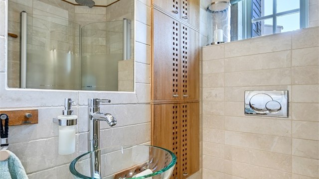 Badet i første etasje er flislagt og har elektriske varmekabler i gulvet. Rommet er utstyrt med vegghengt toalett og dusjhjørne.