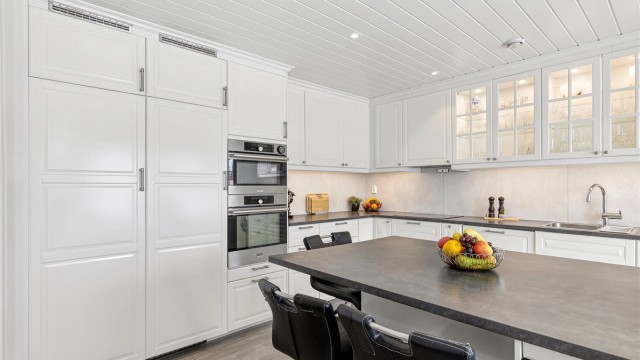 Kjøkkenet har romslig kjøleskap og fryseskap, komfyr og micro, samt oppvaskmaskin og vinskap integrert i innredningen