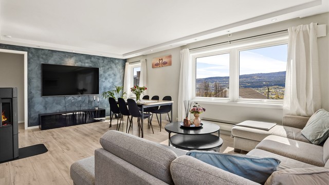 Stuen har god plass til både en romslig sofagruppe og et langbord for sosiale sammenkomster.