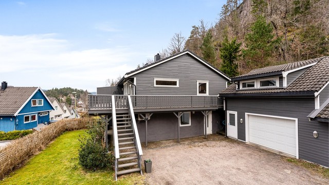 Boligen har en opparbeidet hage på fremsiden, gruset oppkjørsel og en flott innholdsrik garasje med innredet loft - la oss ta en titt!