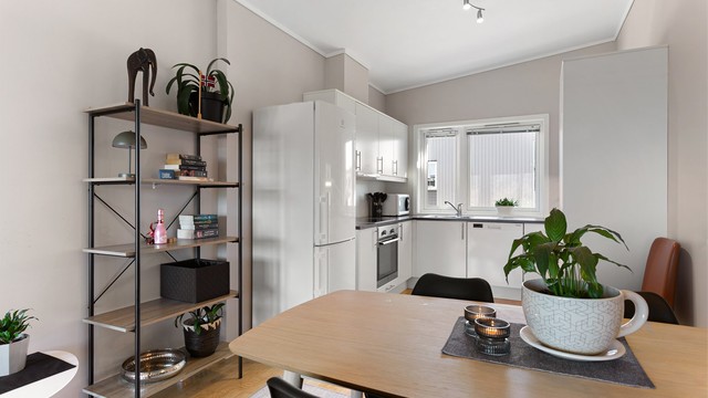 Kjøkkeninnredningen fra byggeåret har glatte fronter og laminert benkeplate.