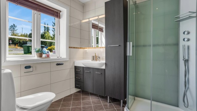 Flislagt bad, med gulvvarme. Badet er videre bestående av servant innredning, speilskap, gulvstående toalett og dusjkabinett.
Videre fra badet finner du vaskerom - med opplegg for vaskemaskin.