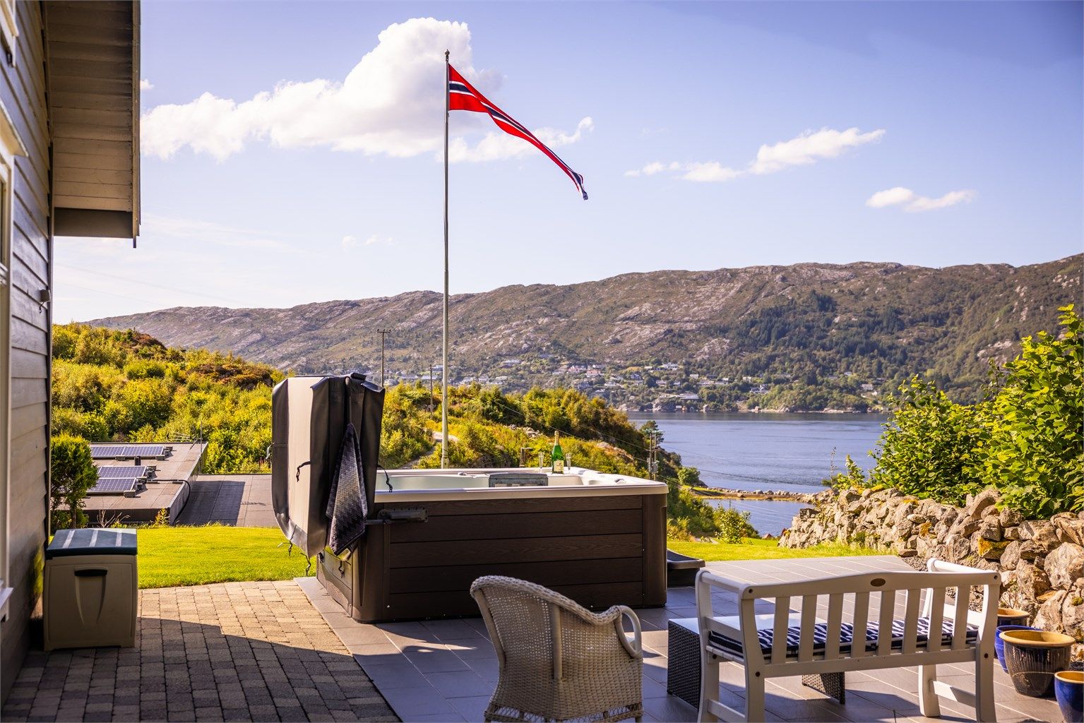 En herlig og skjermet uteplass på eiendommens nordside. Legg også merke til den fine steingarden.