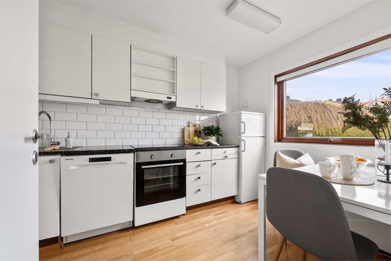 På kjøkken er det bra med skapplass, skuffer- og benkeplass, samt stort vindu, som gir lysinnslipp og utsikt mot inngangsparti. 