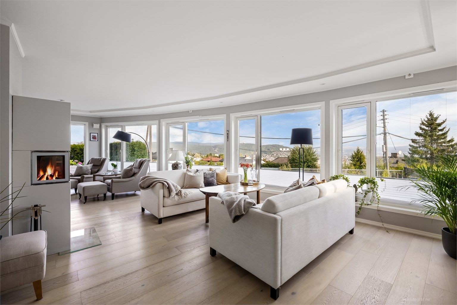 Lys og romslig stue med sofaområde og sittegruppe