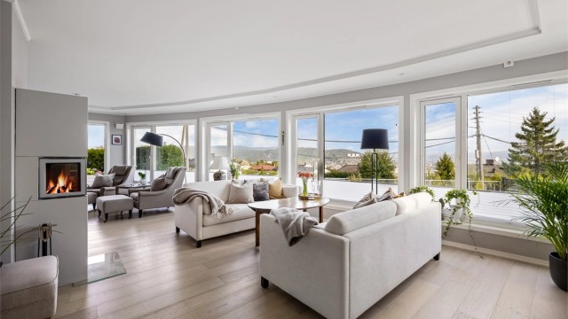 Lys og romslig stue med sofaområde og sittegruppe