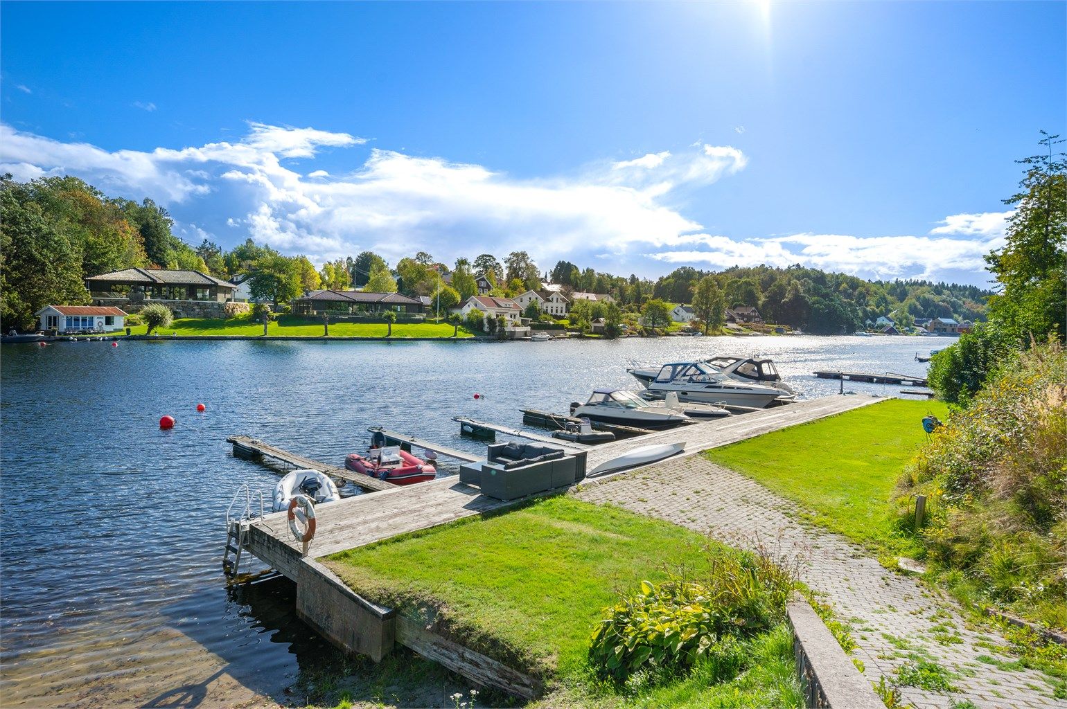 Like nedenfor eiendommen er det bryggeanlegg med badestige og sandstrand som disponeres av beboerne på feltet.