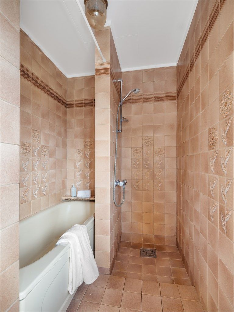 Badet har badekar og dusjnisje