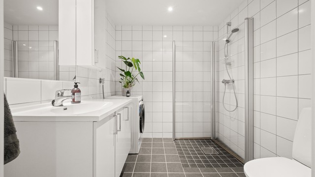 Stort, flislagt bad med elektrisk gulvvarme og downlights.
