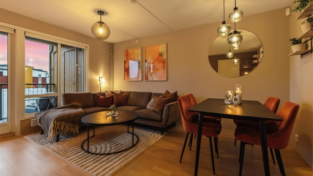 Malte veggflater i behaglige farger gir en lun atmosfære til leiligheten på kveldstid.